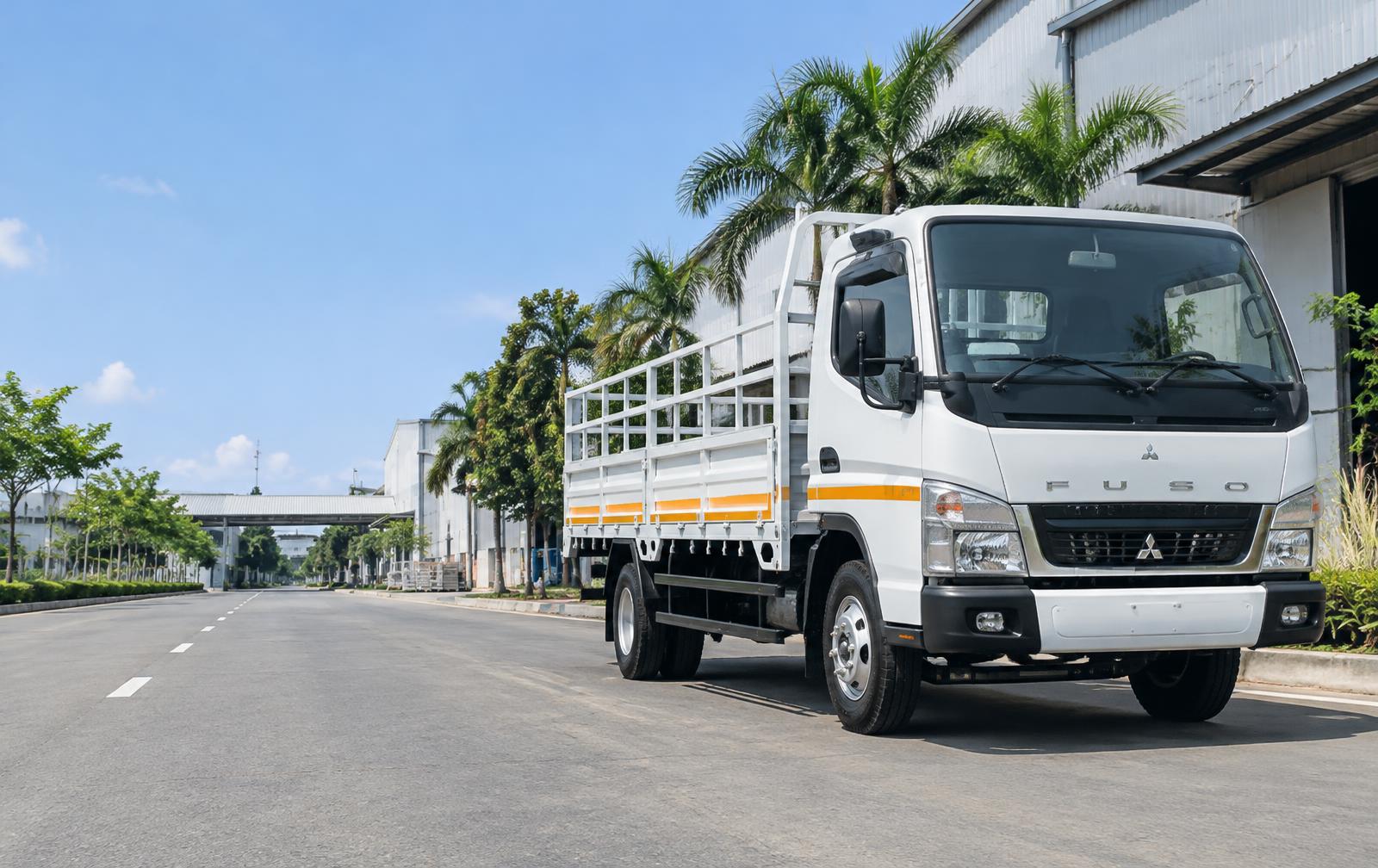 Truk bak terbuka Mitsubishi Fuso putih beraksen oranye di kawasan industri Sidoarjo, Jawa Timur